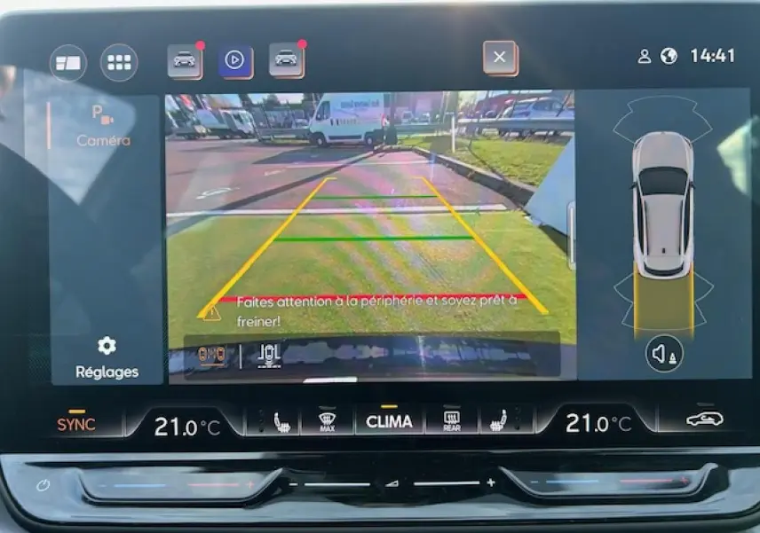 Écran tactile du système d'info-divertissement montrant la caméra de recul du CUPRA Formentor blanc neige en stationnement.