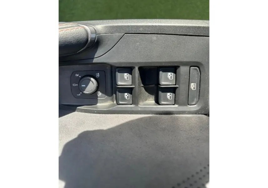 Gros plan sur les commandes de lève-vitres et réglage des rétroviseurs côté conducteur d'une CUPRA Formentor blanc neige.