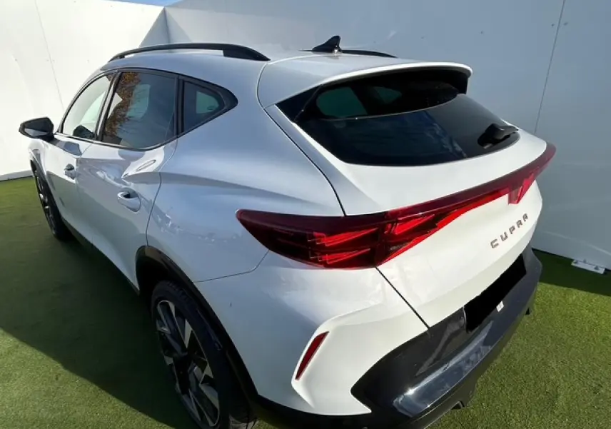 Vue 3/4 arrière droite du CUPRA Formentor blanc neige avec feux arrière Tri-LED et jantes alliage 19 pouces Sandstorm.