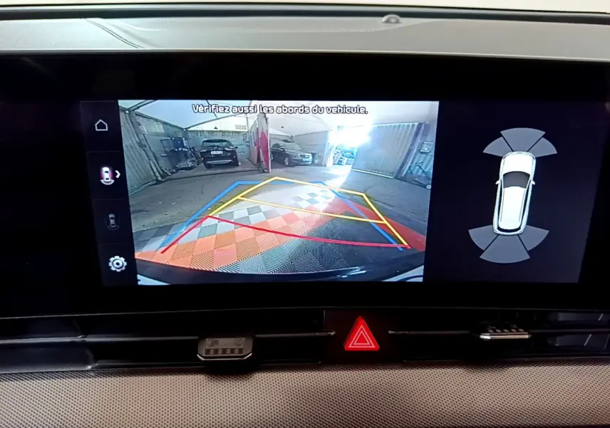 Affichage de la caméra de recul et aide au stationnement sur écran tactile du Kia Sportage blanc 2022, vue intérieure.