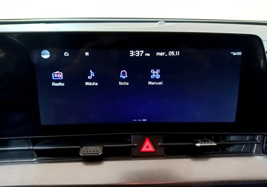 Écran tactile central allumé du tableau de bord du KIA SPORTAGE blanc, affichant les options Radio, Média, Note et Manuel.