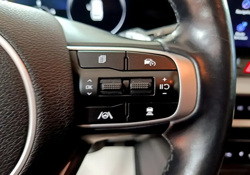 Gros plan sur les commandes multifonctions côté droit du volant cuir du KIA SPORTAGE blanc 2022 hybride rechargeable.