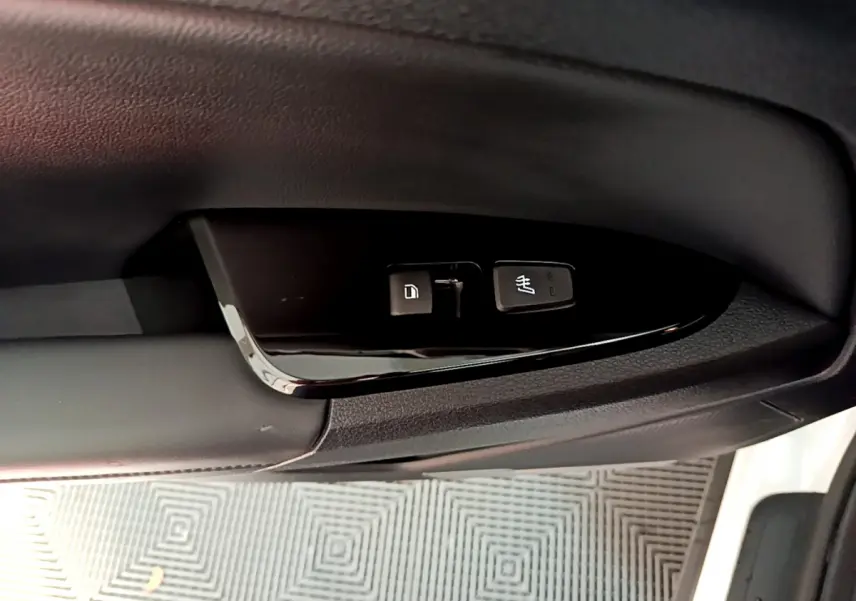 Gros plan sur les commandes de verrouillage et siège chauffant côté conducteur du KIA Sportage blanc 2022.