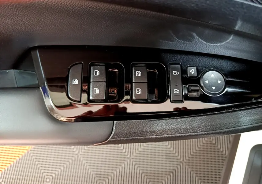 Gros plan sur les commandes de lève-vitres et rétroviseurs côté conducteur du KIA SPORTAGE blanc 2022.