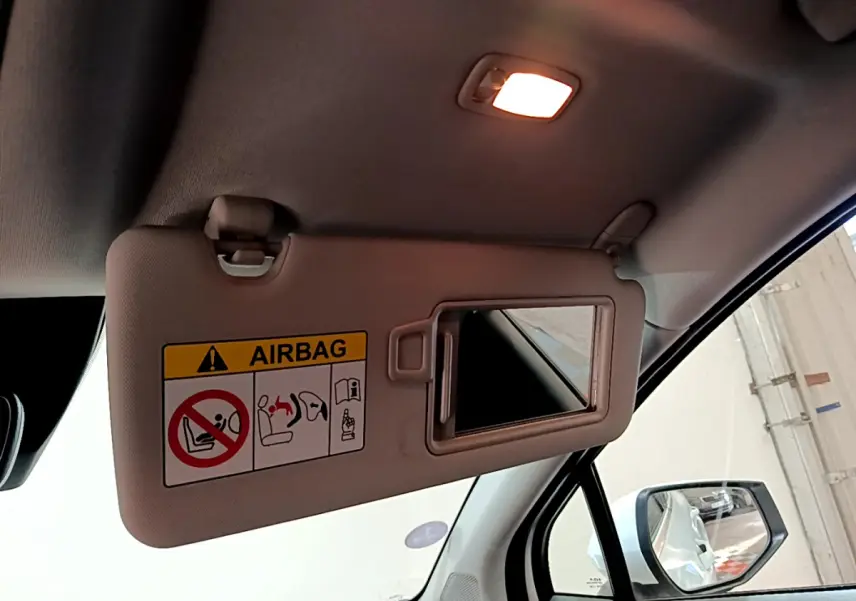 Miroir de pare-soleil côté conducteur avec avertissement airbag, intérieur clair du Kia Sportage blanc 2022.