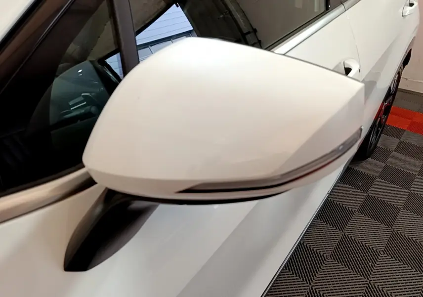 Rétroviseur blanc côté gauche du Kia Sportage 2022 hybride rechargeable, avec clignotant intégré et carrosserie blanche visible.