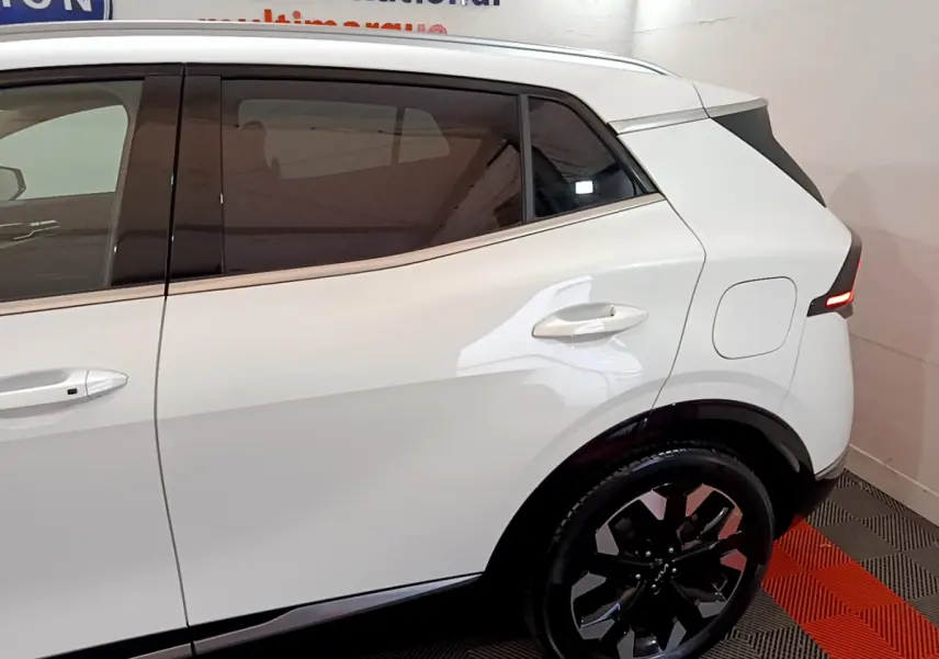 Vue latérale droite du KIA SPORTAGE blanc 2022, mettant en valeur les vitres teintées et la jante noire design.