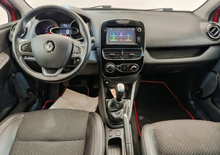 Vue intérieure avant de la Renault Clio Intens rouge, avec volant cuir multifonctions et écran tactile central 7 pouces.