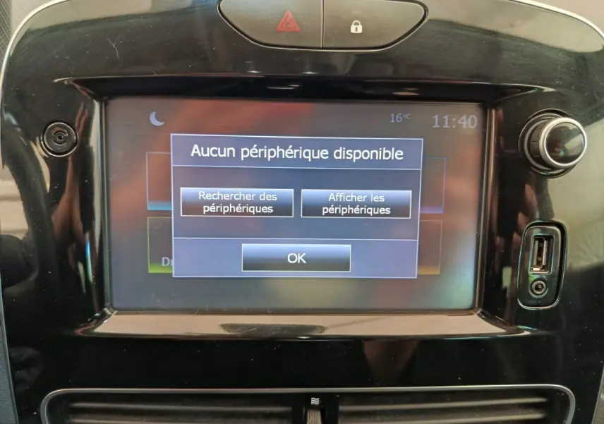 Écran tactile central de la Renault Clio Intens rouge de 2018 affichant un message Bluetooth, entouré de commandes noires brillantes.