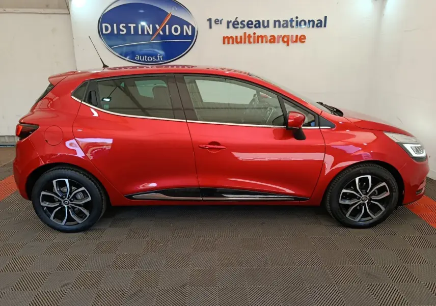 Profil droit d'une Renault Clio Intens Energy TCe 90 rouge de 2018, avec jantes alliage et poignées de porte intégrées.