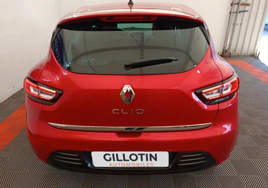 Vue arrière d'une Renault Clio rouge 2018 avec feux LED et logo chromé bien visibles.