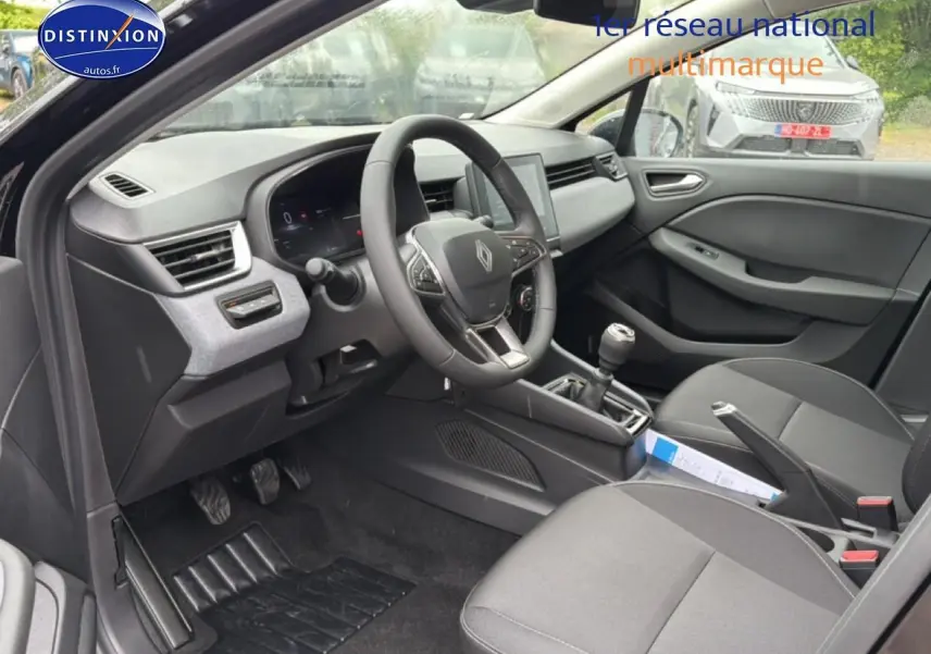 Intérieur avant droit de la Renault Clio V noire 2026, volant multifonction, écran tactile et boîte manuelle visibles.