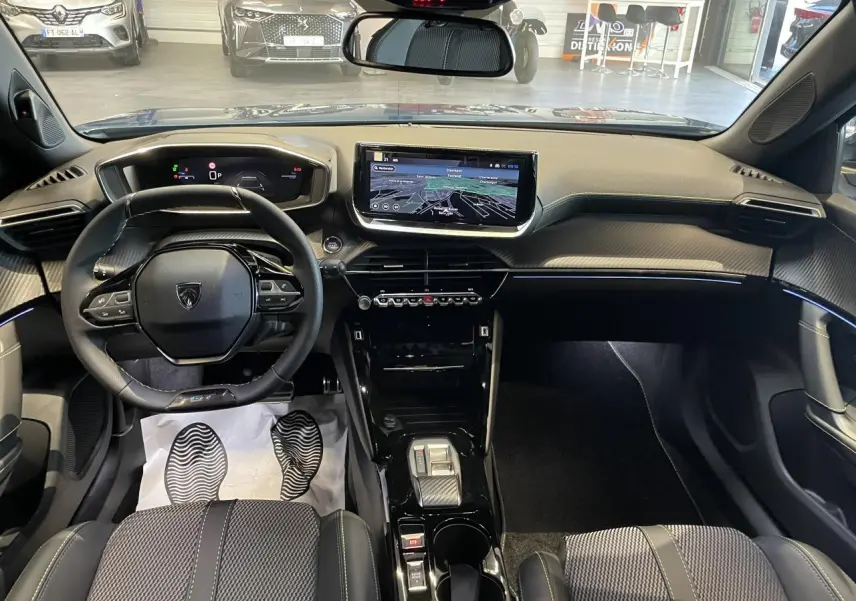 Vue intérieure avant du Peugeot 2008 hybride 2026 avec tableau de bord numérique et écran tactile central.