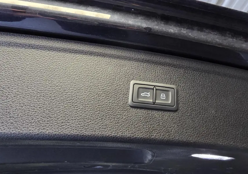 Boutons de commande pour ouverture et verrouillage du coffre sur la trappe intérieure d'un Audi Q5 bleu.