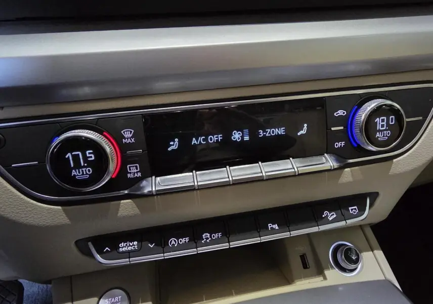 Tableau de bord beige de l'Audi Q5 2019 avec commandes climatisation 3 zones et boutons multifonctions.