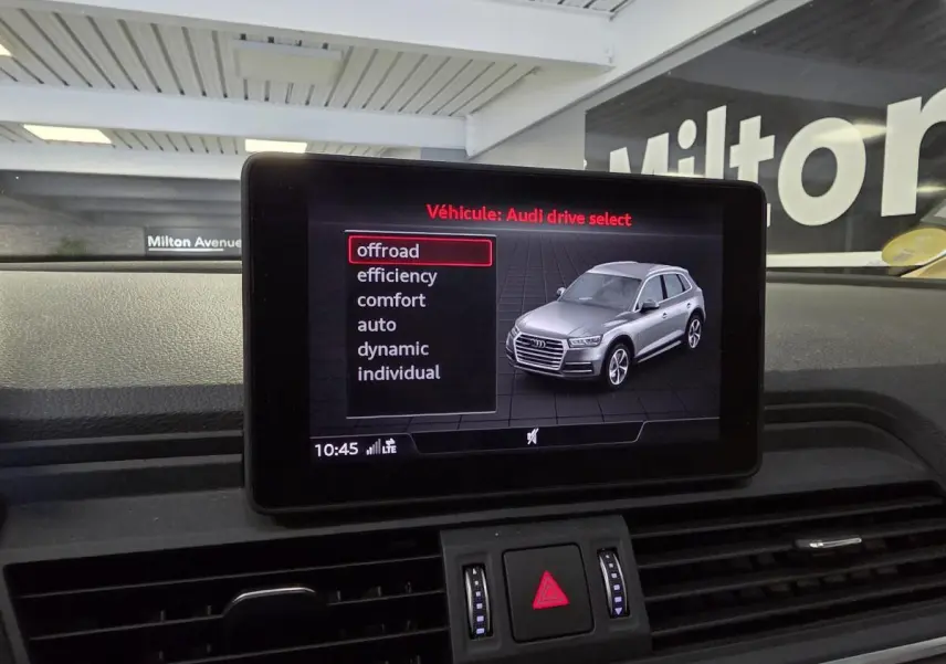 Écran central affichant le menu Audi drive select avec illustration d'un Q5 gris en vue 3/4 avant.