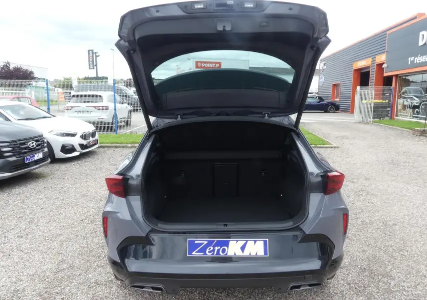 Vue arrière ouverte du coffre du CUPRA Formentor gris Graphène avec double sortie d’échappement et feux LED triangulaires.