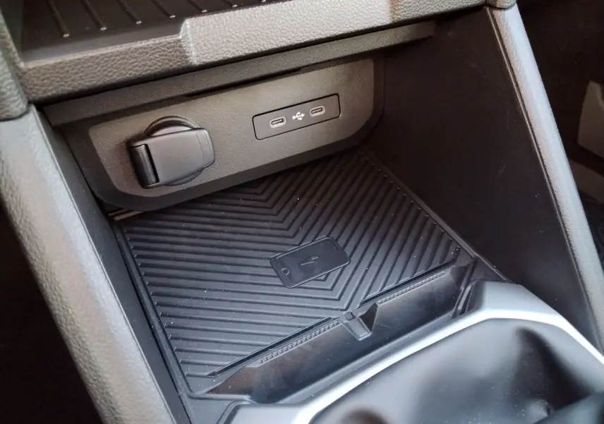 Gros plan sur la console centrale noire du Dacia Bigster 2025, montrant les ports USB et un espace de rangement antidérapant.