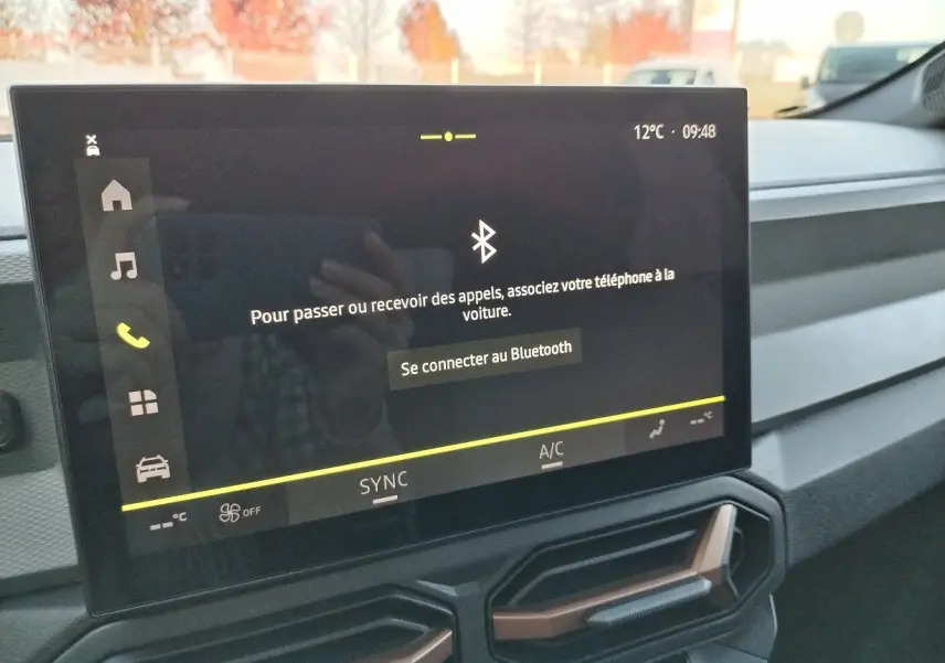 Écran tactile central du tableau de bord du Dacia Bigster 2025 affichant la connexion Bluetooth, avec aérateurs hexagonaux en dessous.