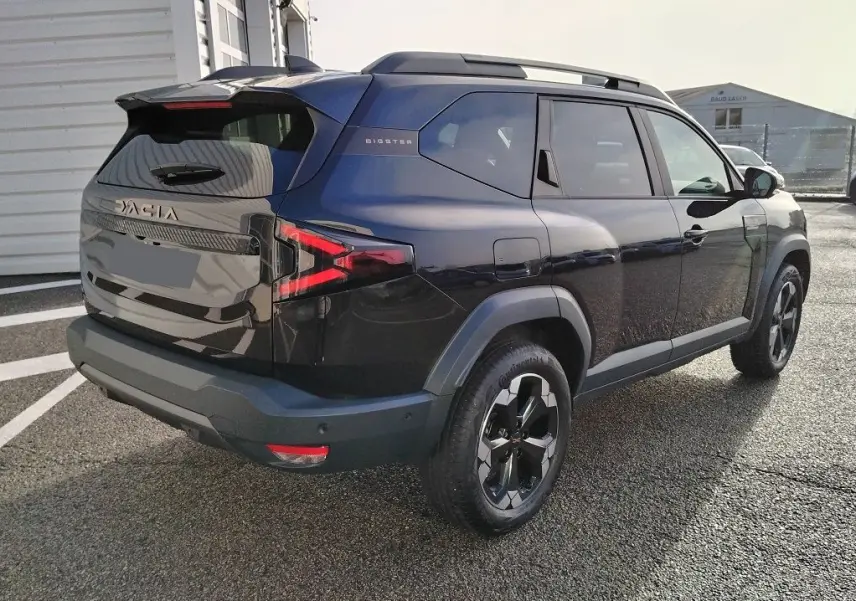 Vue 3/4 arrière droite du SUV noir Dacia Bigster 2025 avec jantes noires et feux arrière LED distinctifs.
