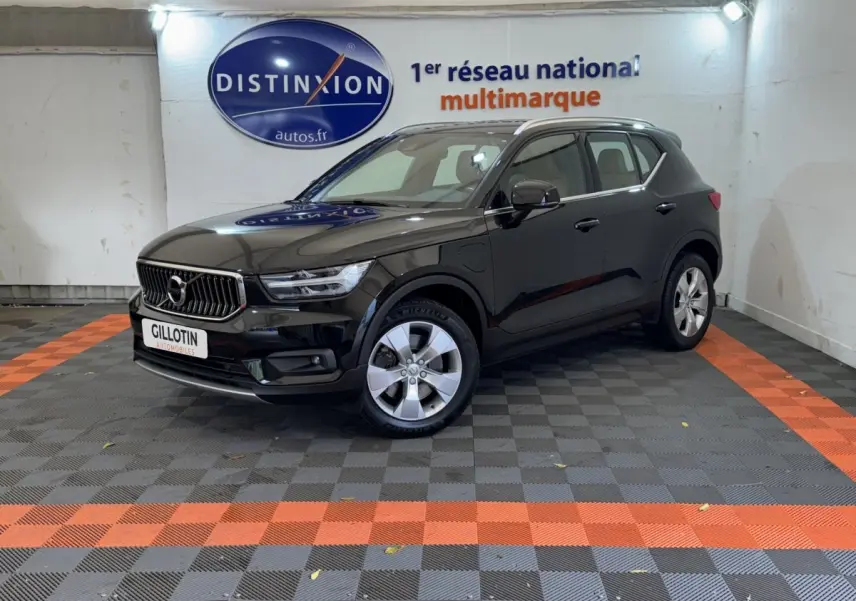 Volvo XC40 Recharge T5 noir en 3/4 avant droit, stationné en intérieur sur sol à damiers gris et orange.