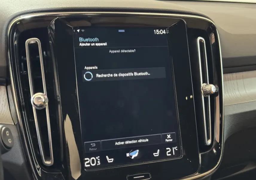 Écran tactile central noir du Volvo XC40 Recharge T5 Inscription 2021, avec commandes climatisation affichées.