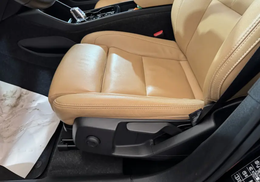 Gros plan sur le siège avant droit en cuir beige du Volvo XC40 Recharge T5 2021, avec commandes de réglage visibles.