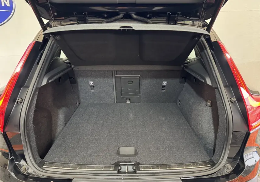 Coffre ouvert noir du Volvo XC40 Recharge T5 262 DCT7 Inscription, vue arrière montrant l'espace de chargement vide.