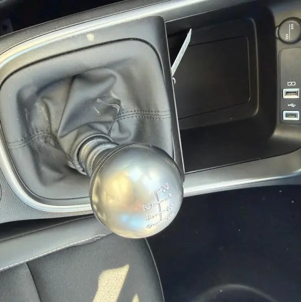 Gros plan sur le levier de vitesses manuel noir de la Jeep Avenger 2025, avec console centrale et ports USB visibles.