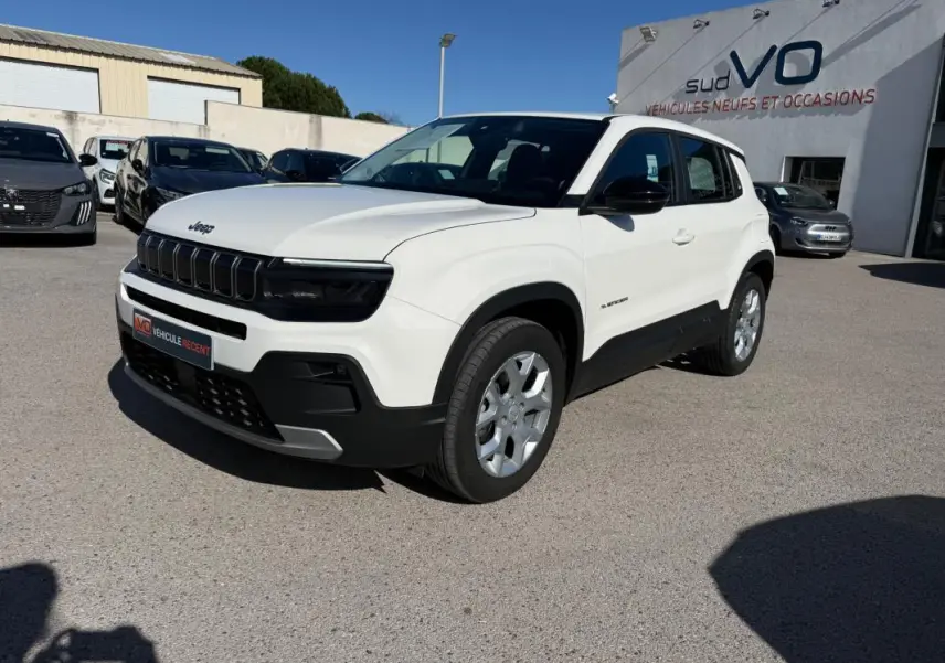 Jeep Avenger blanc en vue 3/4 avant droit, avec calandre noire et jantes alliage 17 pouces visibles.