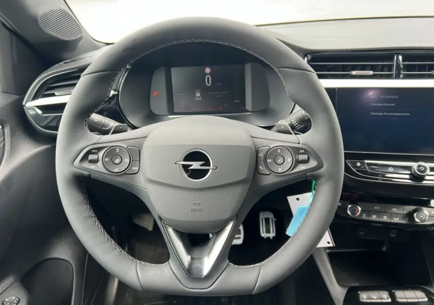 Vue rapprochée du volant cuir multifonctions Opel Corsa Hybrid 2026 avec tableau de bord numérique et écran tactile.