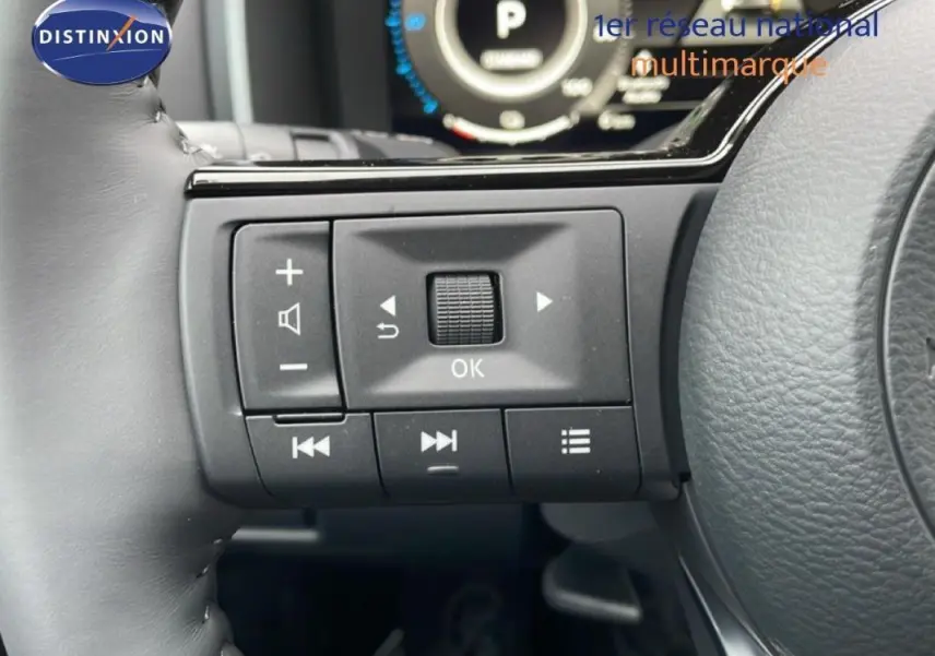 Gros plan sur les commandes multifonctions à gauche du volant du Nissan Qashqai noir 2025, affichage digital en arrière-plan.
