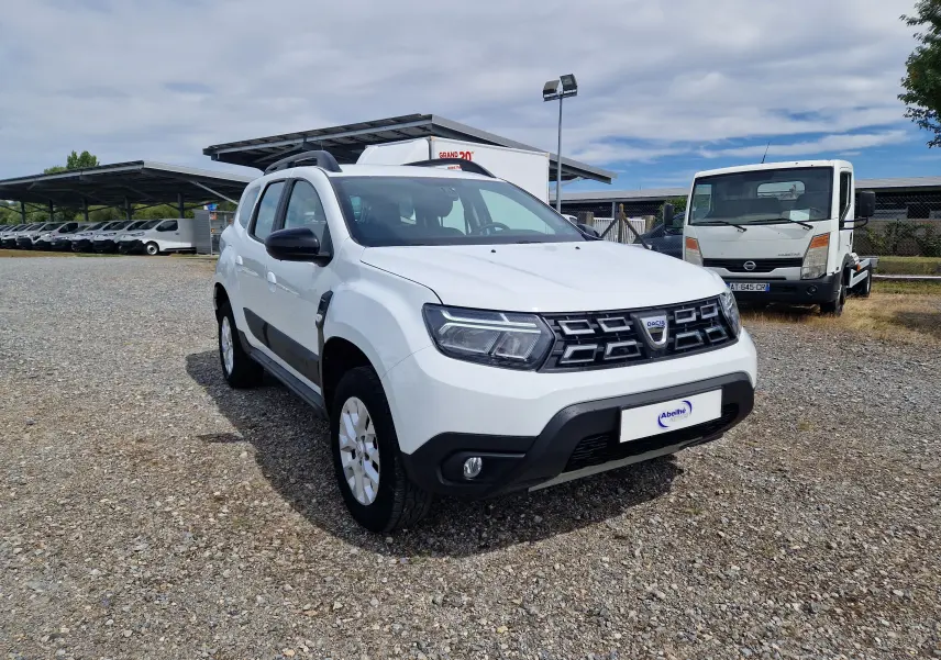 Dacia Duster blanc vue 3/4 avant droit, SUV 4x4 avec calandre noire et jantes alliage 16 pouces.