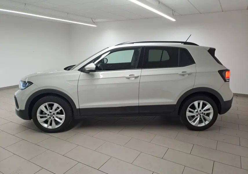 Volkswagen T-Cross Gris Ascot vue de profil côté gauche en intérieur, avec jantes alliage et toit noir contrasté.