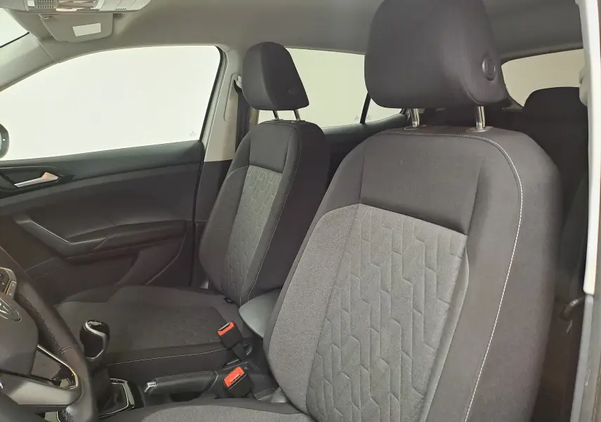 Vue intérieure du Volkswagen T-Cross 2024 montrant les sièges avant en tissu gris avec motifs géométriques.