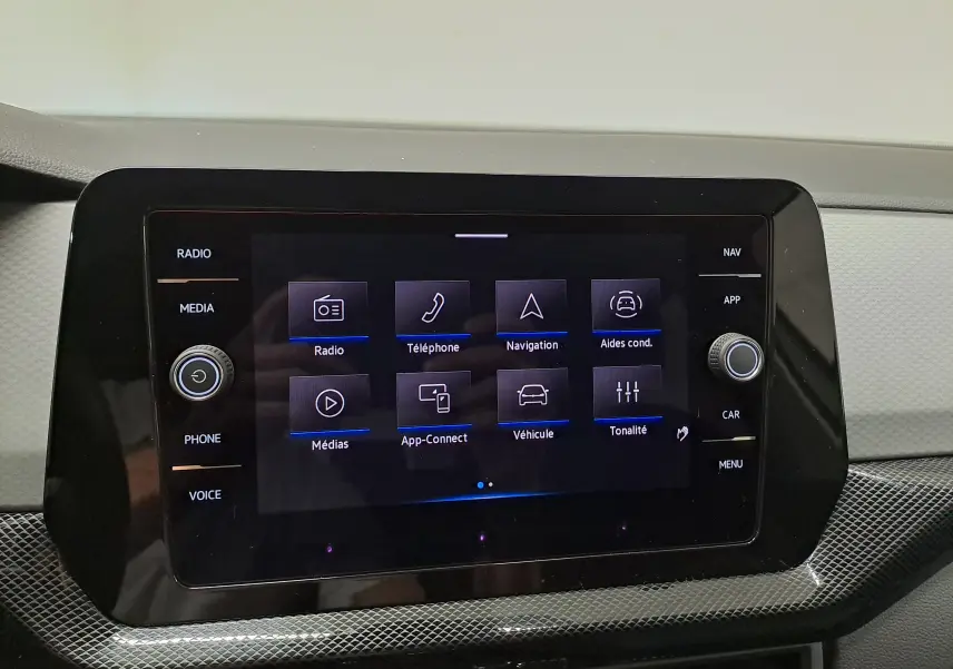 Écran tactile central du Volkswagen T-Cross 2024 affichant les options radio, téléphone, navigation et aides à la conduite.