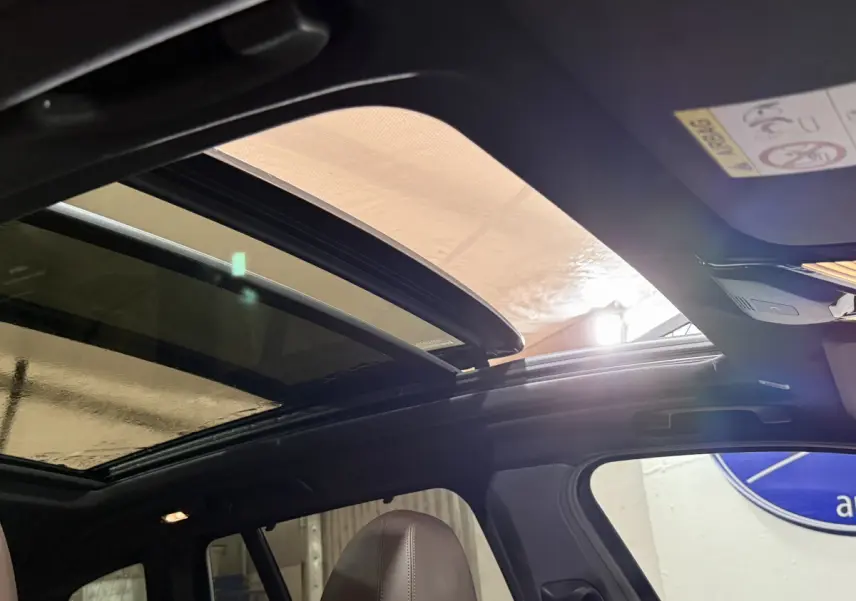 Toit ouvrant panoramique ouvert vu de l'intérieur côté conducteur d'un BMW X3 bleu 2023 M Sport