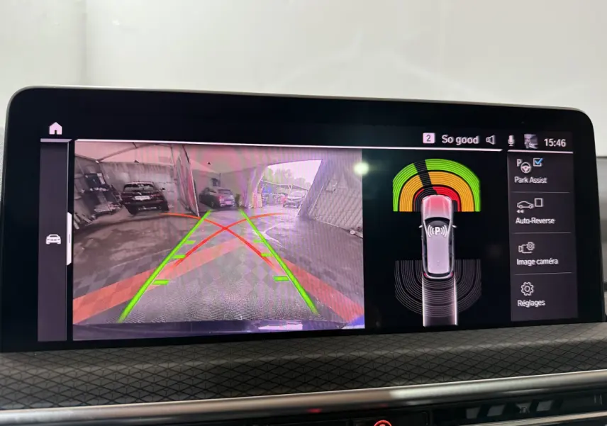 Écran central du BMW X3 xDrive30e 2023 montrant l'aide au stationnement arrière avec vue caméra et capteurs actifs.