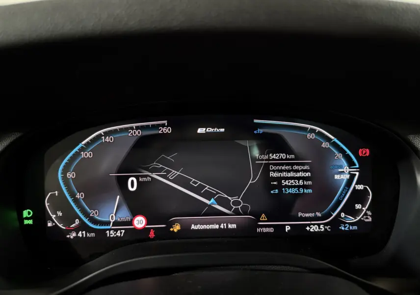Tableau de bord numérique du BMW X3 xDrive30e 2023 affichant la navigation et l'autonomie en mode hybride.