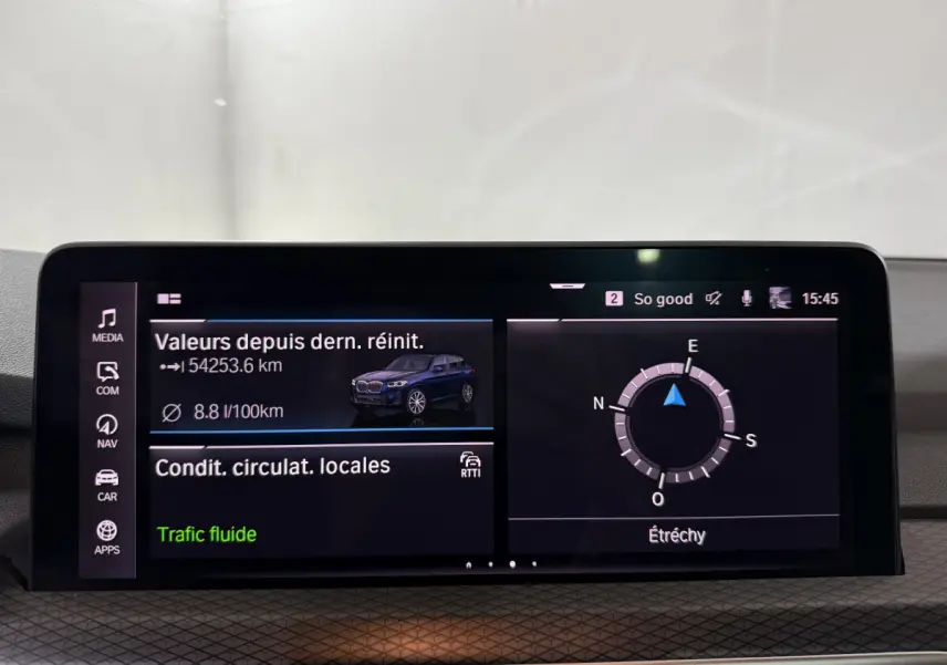 Écran tactile central du tableau de bord du BMW X3 bleu, affichant consommation et navigation en intérieur.