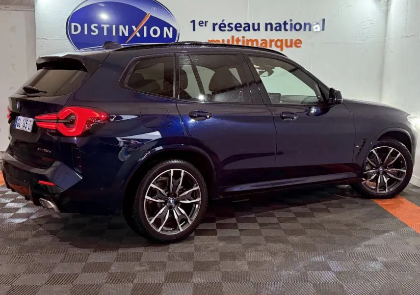 BMW X3 xDrive30e bleu vue de profil côté droit, avec jantes alliage et feux arrière LED distinctifs.