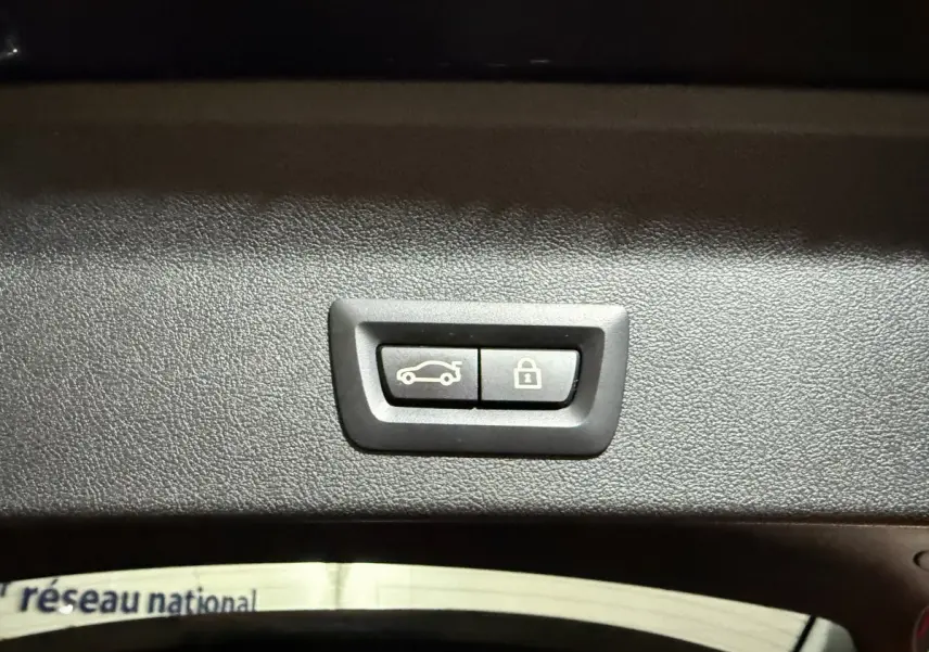 Gros plan sur les boutons d'ouverture et de verrouillage électrique du coffre du BMW X3 xDrive30e bleu 2023.