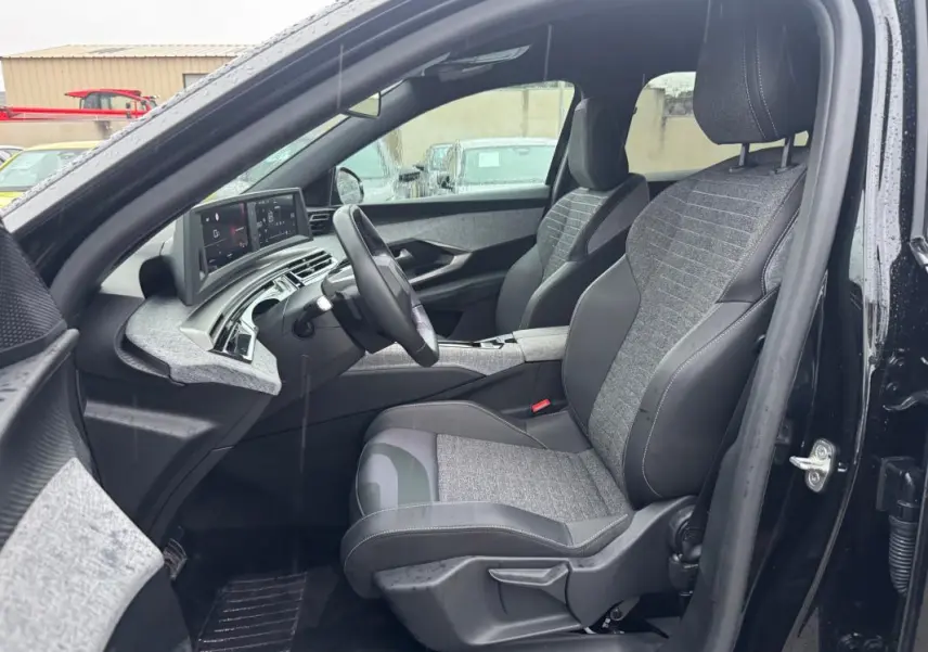 Vue intérieure côté conducteur du Peugeot 3008 Hybrid 145 e-DCS6 Allure noir, avec sièges tissu et cuir et tableau de bord numérique.