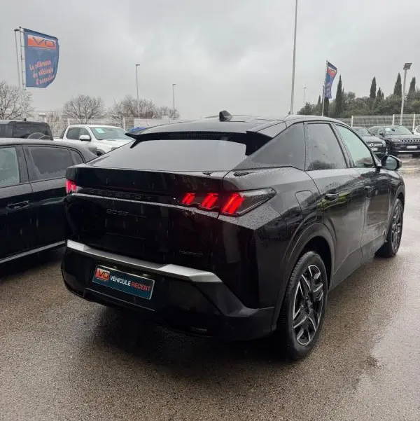 Vue 3/4 arrière droite d’un Peugeot 3008 Hybrid 145 noir avec feux arrière allumés et jantes alliage 19 pouces.