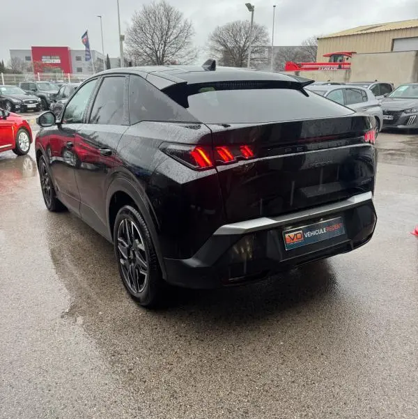 Vue 3/4 arrière droite d’un Peugeot 3008 Hybrid 145 noir avec feux arrière allumés et jantes alliage 19 pouces.