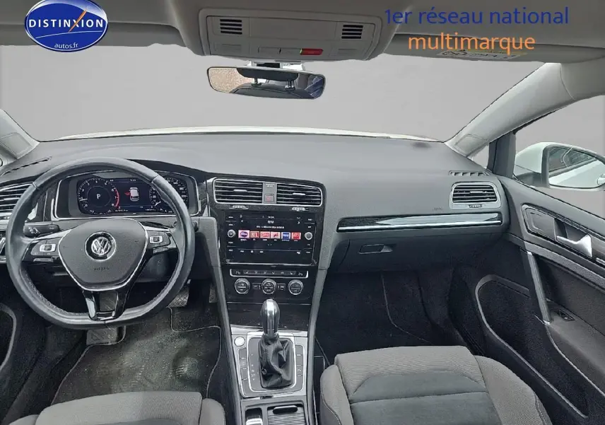 Vue intérieure avant de la Volkswagen Golf blanche 2019, tableau de bord et volant multifonction en cuir visibles.