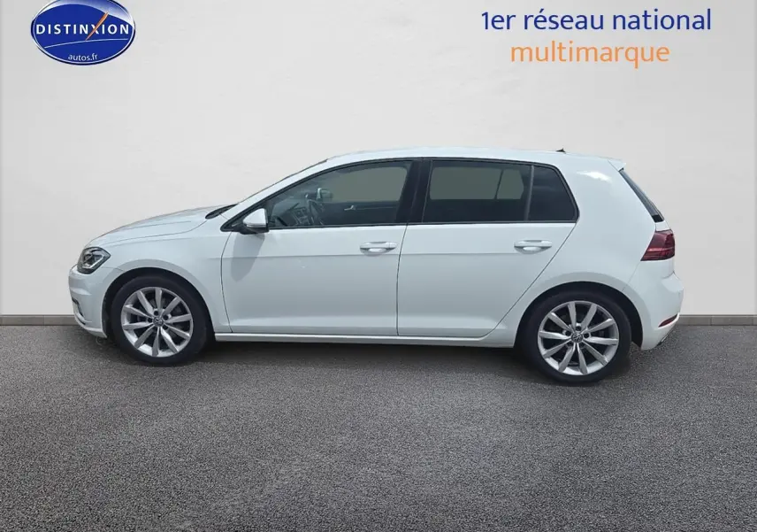 Profil côté gauche d’une Volkswagen Golf blanche 2019 avec jantes alliage et vitres teintées.