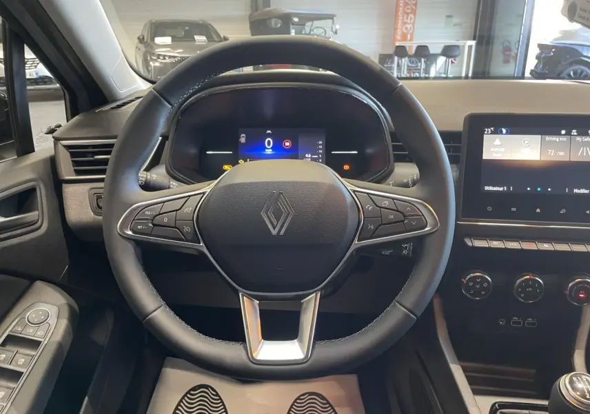 Vue intérieure centrée sur le volant multifonction Renault Clio 1.5 Blue dCi gris Rafale avec tableau de bord numérique.