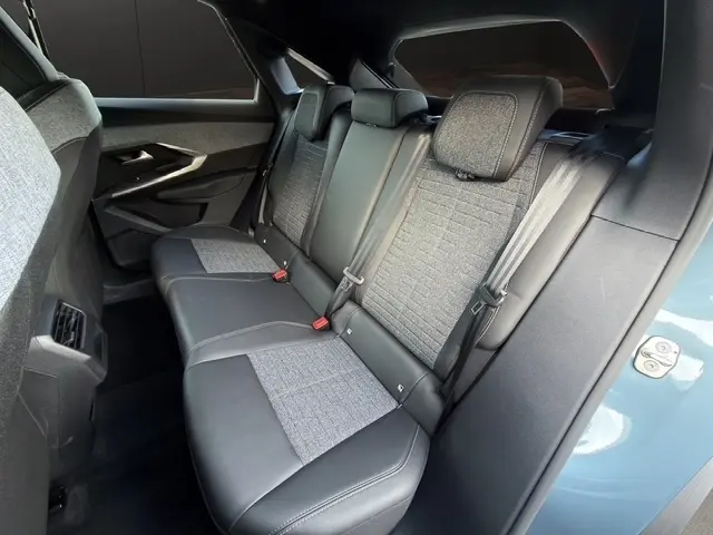 Vue intérieure arrière côté droit du Peugeot 3008 bleu 2026, montrant la banquette mixte cuir et tissu avec ceintures de sécurité.