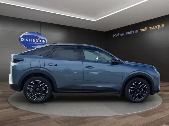 Profil côté gauche d'un Peugeot 3008 bleu 2026 avec jantes 19 pouces, dans un showroom intérieur moderne.
